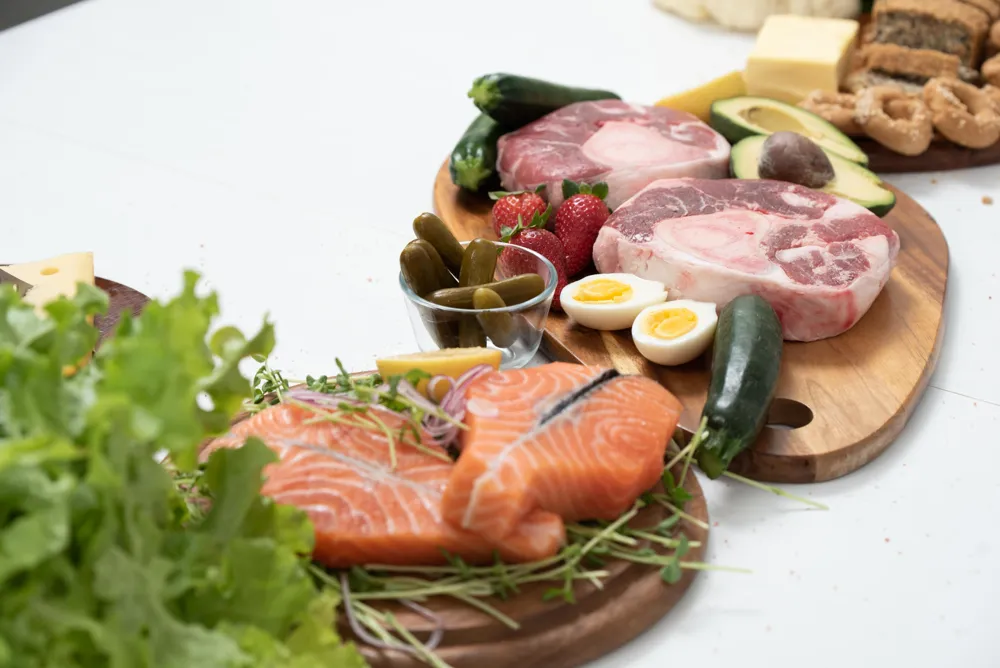 Saumon cru, pièces de bœuf et œufs durs sur une planche en bois