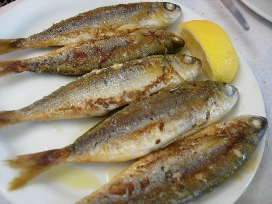 Assiette de sardines grillées servies avec un quartier de citron