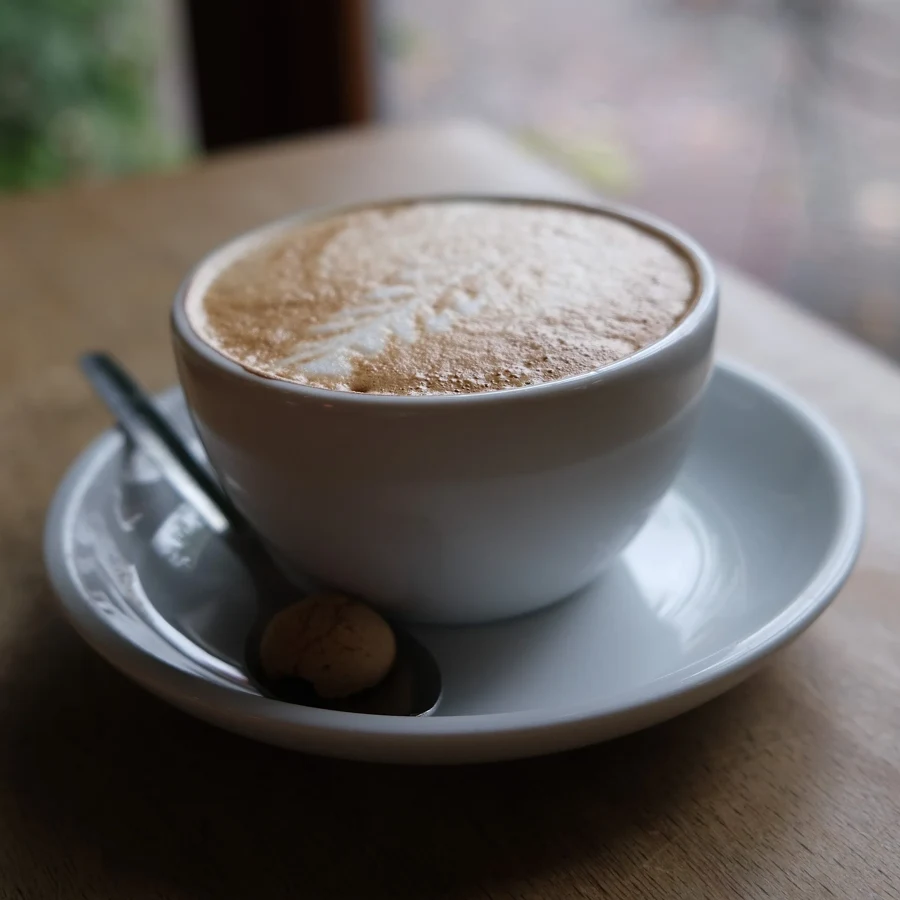 Une tasse de café posée sur une table en bois