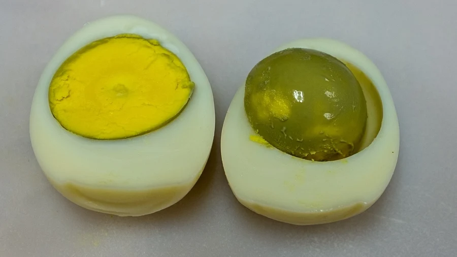 Deux œufs durs coupés en deux, l&rsquo;un au jaune jaune vif, l&rsquo;autre trop cuit au jaune verdâtre