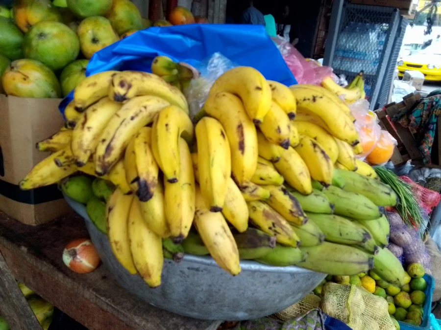 Bananes et agrumes sur un étal de marché, des fruits au PRAL négatif